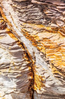 Coloured, ferruginous mineral sandstone on Topinetti beach, near Rio Marina, Elba, Tuscan