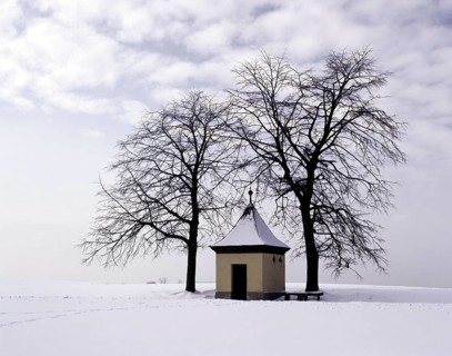 Small chapel in the Franconian Forest in winter, between two trees in a snowy landscape, district