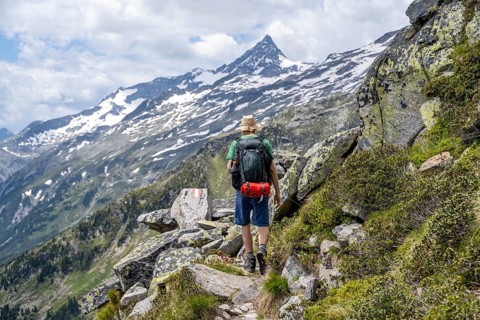 Mountaineer on rocky hiking trail, Berliner Hoehenweg, mountain panorama with summit Schrammacher,