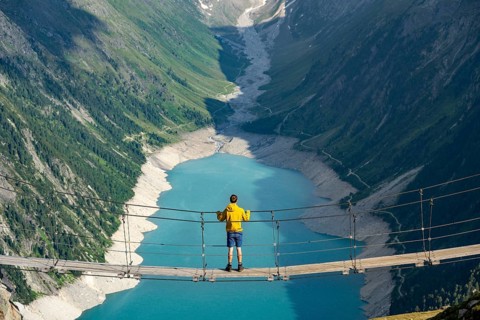 Mountaineers on a suspension bridge, picturesque mountain landscape near the Olpererhuette, view of