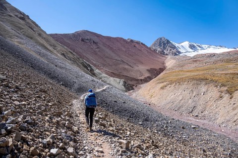 Barren high mountains, hiker on the hiking trail to the base camp of Lenin Peak, Osh Province,
