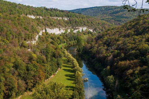 River with gorge and autumnal coloured forest, valley of the Loue, Lizine, near Besancon,