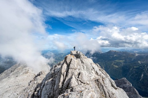 Mountaineer on the rocky summit of the Watzmann Mittelspitze, Watzmann crossing, view of mountain