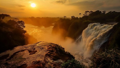Sunset over a powerful Inga waterfall in the democratic republic of Congo with mist rising and the