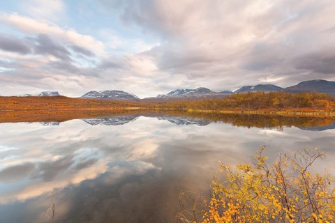 Abisko National Park in autumn, Lake Vuolep Njakajaure. Reflection of the mountains in the lake