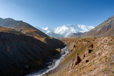 Achik Tash river, Achik Tash valley, behind glaciated and snow-covered mountain peak Pik Lenin,