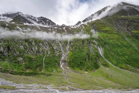 Mountain streams flow over steep mountain slopes into the tagl of the Schlegeisgrund, cloudy rocky