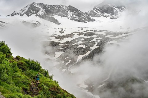 Mountaineers on a hiking trail, in the background glaciated peak Dosso Largo and glacier