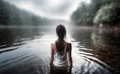 Suicidal thoughts, a young depressive woman with suicidal intent stands in the water by a lake in