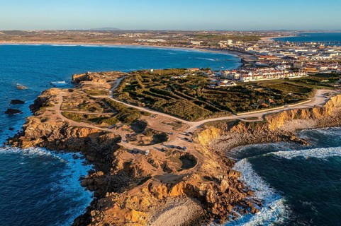 Peniche peninsula with high cliffs and ocean tide at sunset, Portugal. Summer sunset haze, little