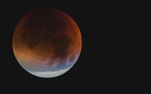 A moon with visible orange and blue tones during a partial lunar eclipse, Haan, North