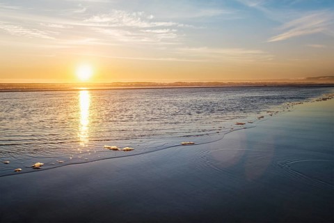 Atlantic ocean sunset with surging waves at Fonte da Telha beach, Costa da Caparica, Portugal,