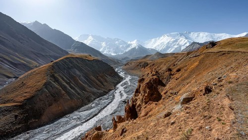 Achik Tash river, Achik Tash valley with rock formations, behind glaciated and snow-covered