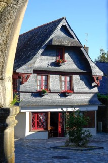 Rue du General de Gaulle in the old town centre of Le Faou with slate-roofed granite houses from