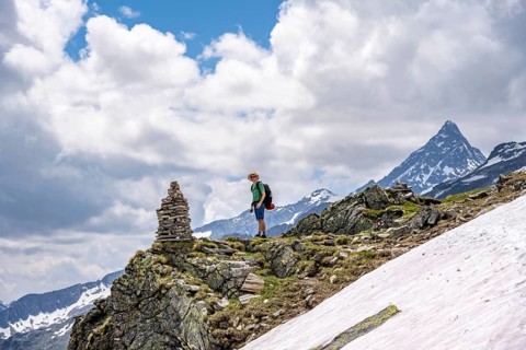 Mountaineer on a rocky hiking trail with cairns, Berliner Hoehenweg, mountain landscape with