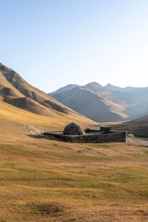 Historic caravanserai Tash Rabat from the 15th century, in the evening light with golden hills,
