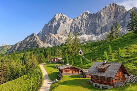Mountain hut and alp in front of steep mountains in summer, Brandalm, Hoher Dachstein, Austria,