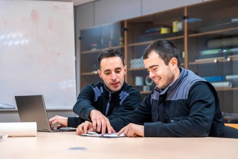 Two engineers talking sitting in a meeting room of a factory