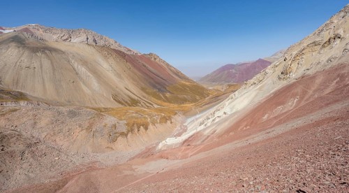 Mountain landscape of glacial moraines, mountains with red and yellow rocks, Traveller's Pass below
