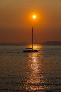 Sailing ship at sunrise in the bay of Gaia di Mola, off Porto Azzurro, Elba, Tuscan Archipelago,