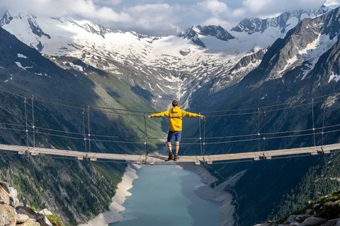 Mountaineers on a suspension bridge, picturesque mountain landscape near the Olpererhuette, view of