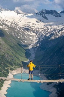 Mountaineers on a suspension bridge over a mountain stream Alelebach, picturesque mountain