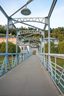 Pedestrian bridge with blue steel construction and clear sky in the background, Mozartsteg