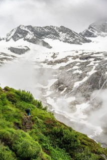 Mountaineers on a hiking trail, in the background glaciated peak Dosso Largo and glacier