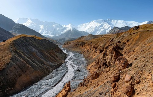 Achik Tash river, Achik Tash valley with rock formations, behind glaciated and snow-covered