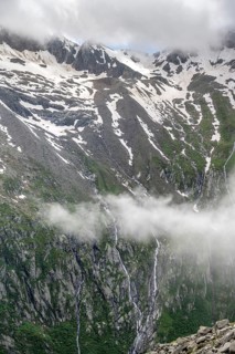 Snow-covered cloudy mountains, mountain streams as waterfalls on a mountain slope, Furtschaglhaus,
