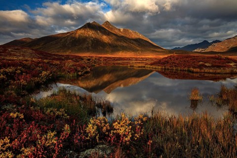 Reflection of mountains in a small lake in morning light, clouds, tundra, autumn, Dempster Highway,