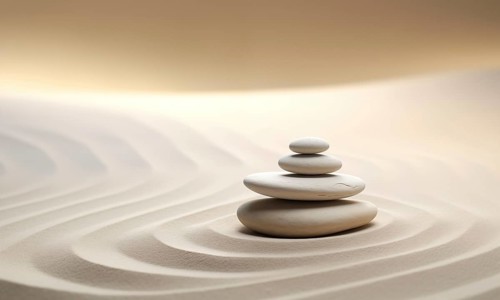 Zen stones stack on raked sand in a minimalist setting for balance and harmony. Balance, harmony,