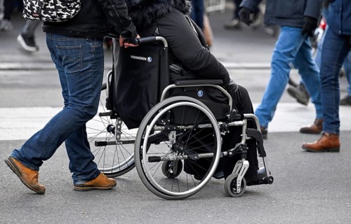 Symbol photo Man pushing wheelchair