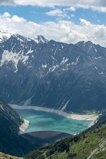 Dam, dam wall of the Schlegeis reservoir in a mountain valley, reservoir lake with turquoise blue