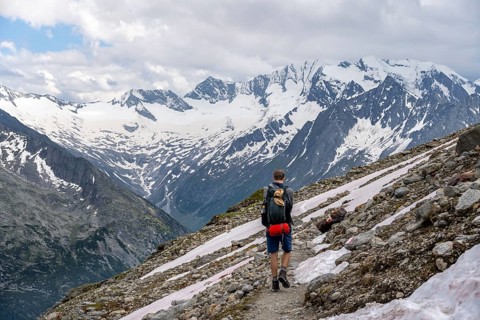 Mountaineer on hiking trail, Berliner Hoehenweg, mountain landscape with glaciated peaks Hochfeiler