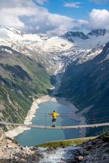 Mountaineers on a suspension bridge over a mountain stream Alelebach, picturesque mountain