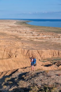 Photographer photographs canyons and eroded hilly landscape, Badlands, Valley of the Forgotten