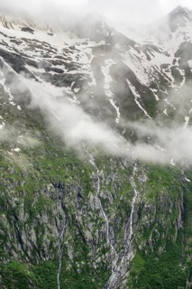 Snow-covered cloudy mountains, mountain streams as waterfalls on a mountain slope, Furtschaglhaus,