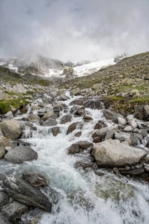 Mountain stream Furtschaglbach, behind rocky mountains with glacier Furtschaglkees, Furtschaglhaus,