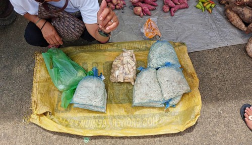 Vendor sitting and waiting for costumers at a farmer's market selling local organic vegetable,