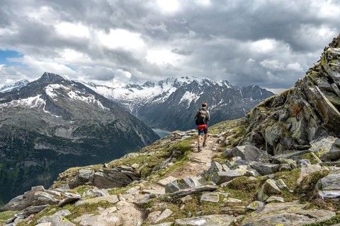 Mountaineer on hiking trail with snow, Berliner Hoehenweg, mountain landscape with glaciated peaks