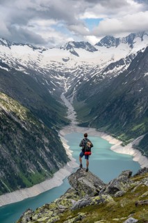 Mountaineer on a rock in front of a mountain panorama, view of Schlegeisspeicher, glaciated rocky