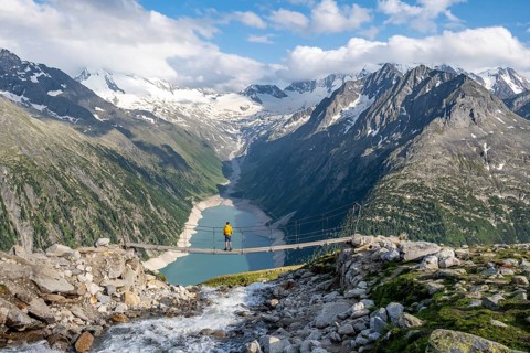 Mountaineers on a suspension bridge over a mountain stream Alelebach, picturesque mountain