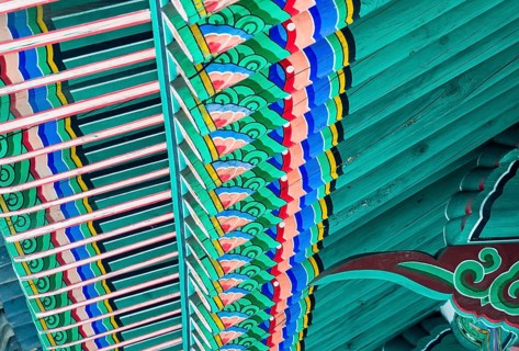 Underside of the roof of a pagoda with vivid colors painted in oriental design