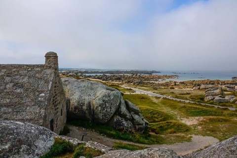 Former village of Meneham on the Atlantic coast with house between granite rocks, coast on the