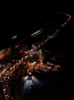 Night view of an illuminated road full of tractors and people, farmers protest, Black Forest, Bad
