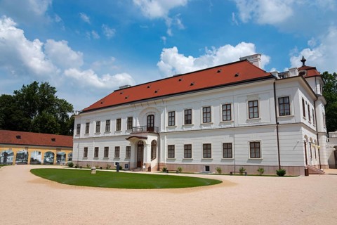 Baroque castle with a red roof and white facade surrounded by a well-tended garden, Esterhazy