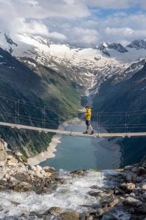 Mountaineers on a suspension bridge over a mountain stream Alelebach, picturesque mountain