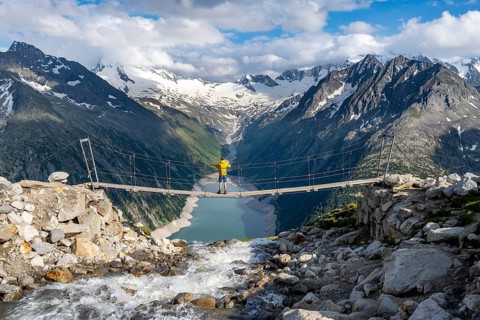 Mountaineers on a suspension bridge over a mountain stream Alelebach, picturesque mountain