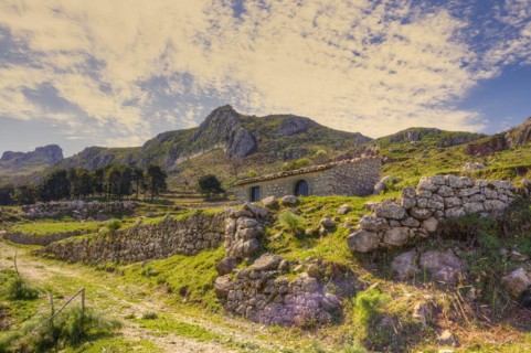 Traditional farmhouse surrounded by stone walls in a hilly landscape, near Novara di Sicilia,